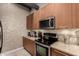 A beautifully designed kitchen offers modern appliances, wooden cabinetry, and stylish backsplash at 1 E Lexington Ave # 1210, Phoenix, AZ 85012