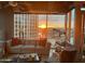 Bright living room with a comfortable gray sofa and an outdoor view of the sun setting over the cityscape at 1 E Lexington Ave # 1210, Phoenix, AZ 85012