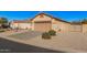 Single-story home with desert landscaping, a two-car garage and a decorative wrought iron side gate at 10352 E Second Water Trl, Gold Canyon, AZ 85118