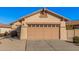 Beige stucco home featuring a large garage with attractive detailing above the door and a low maintenance yard at 10352 E Second Water Trl, Gold Canyon, AZ 85118