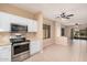 Well-lit kitchen with stainless steel appliances, white cabinets, and tile flooring, open to the living space at 10352 E Second Water Trl, Gold Canyon, AZ 85118