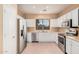 Bright kitchen with stainless steel appliances, white cabinetry, tile floors, and a window over the sink at 10352 E Second Water Trl, Gold Canyon, AZ 85118