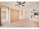 Open-concept living area with neutral paint, tile floors, ceiling fans and an open kitchen in the background at 10352 E Second Water Trl, Gold Canyon, AZ 85118