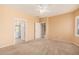 Spacious main bedroom with neutral carpet, ceiling fan, and ample natural light from the windows at 10352 E Second Water Trl, Gold Canyon, AZ 85118