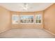 Bright main bedroom featuring plush carpeting, a ceiling fan, and a large window providing natural light at 10352 E Second Water Trl, Gold Canyon, AZ 85118