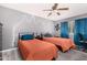 Comfortable bedroom with two beds, a ceiling fan, and stylish blue curtains at 10414 W Ponderosa Cir, Sun City, AZ 85373