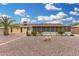 Home exterior showing backyard with desert landscaping, covered patio, and desert plants at 10414 W Ponderosa Cir, Sun City, AZ 85373