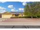 Charming single-story home featuring yellow paint, solar panels, and a low maintenance front yard at 10414 W Ponderosa Cir, Sun City, AZ 85373