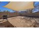 A backyard with a custom sunshade and barbecue grill, with block wall privacy fencing at 10423 W Hughes Dr, Tolleson, AZ 85353