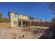 Rear exterior shot of home showing spacious dirt backyard and covered patio at 10423 W Hughes Dr, Tolleson, AZ 85353