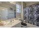 Well-lit bathroom with a floral shower curtain and white vanity at 10423 W Hughes Dr, Tolleson, AZ 85353