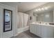 Bathroom showcasing double sinks, neutral walls, decorative mirror, and shower-tub combo at 10423 W Hughes Dr, Tolleson, AZ 85353