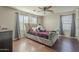 Cozy bedroom features a tufted headboard and wood flooring at 10423 W Hughes Dr, Tolleson, AZ 85353