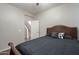 Comfortable bedroom featuring a dark bed and a view to the stairs at 10423 W Hughes Dr, Tolleson, AZ 85353