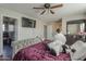 Bedroom featuring a bed, fan, and a view to the hallway at 10423 W Hughes Dr, Tolleson, AZ 85353