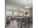 A spacious dining room features an elegant chandelier and gray wooden table and chairs at 10423 W Hughes Dr, Tolleson, AZ 85353