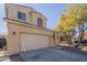 Two-story home featuring a garage, tan stucco exterior and a well-kept lawn at 10423 W Hughes Dr, Tolleson, AZ 85353