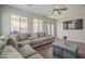 Bright living room with a neutral sectional, wood floors, and recessed lighting at 10423 W Hughes Dr, Tolleson, AZ 85353