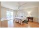 Bright bedroom with a ceiling fan, light hardwood floors and a sliding glass door to the patio at 10461 W Loma Blanca Dr, Sun City, AZ 85351