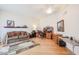 Bright living room featuring hardwood floors, comfortable couch, and functional office space at 10461 W Loma Blanca Dr, Sun City, AZ 85351