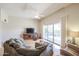 Cozy living room with hardwood floors, comfortable seating, and bright sliding glass doors at 10461 W Loma Blanca Dr, Sun City, AZ 85351