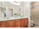 This bathroom features a double sink vanity with wood cabinets and a large mirror at 10684 N 161St Ave, Surprise, AZ 85379