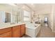 Bright bathroom with dual sinks, garden tub, and a mirrored closet at 10684 N 161St Ave, Surprise, AZ 85379