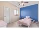 Bedroom featuring a blue accent wall, window, and a bed with pink linens at 10684 N 161St Ave, Surprise, AZ 85379