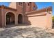 Front exterior showcasing a two-car garage and an arched entry at 10684 N 161St Ave, Surprise, AZ 85379