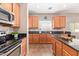 Functional kitchen featuring stainless steel appliances, dark countertops, and light wood cabinets at 10684 N 161St Ave, Surprise, AZ 85379