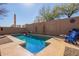 Refreshing in-ground pool with a rock waterfall feature and a sunny patio area at 10684 N 161St Ave, Surprise, AZ 85379