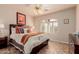 Bedroom showcases a ceiling fan, light fixtures, and arched window at 11530 E Monterey Ave, Mesa, AZ 85209