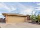 Charming one-story home featuring a spacious brown garage and stone accents at 11530 E Monterey Ave, Mesa, AZ 85209