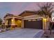 Exterior shot of a tan home with a two-car garage during the evening hours at 12413 W Calle De Baca --, Peoria, AZ 85383