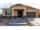 Inviting front entrance with stone accents, desert landscaping, and a covered porch at 12413 W Calle De Baca --, Peoria, AZ 85383