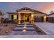 Inviting front exterior features a desert landscape with a covered porch and warm lighting at 12413 W Calle De Baca --, Peoria, AZ 85383