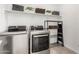 Bright laundry room features modern stainless steel appliances, storage shelf, and stylish decor at 12413 W Calle De Baca --, Peoria, AZ 85383