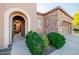 Beautiful front entry with an arched entryway, natural light, and lush landscaping at 12835 W Black Hill Rd, Peoria, AZ 85383