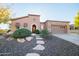 Attractive single-story home featuring low-maintenance desert landscaping, stone accents, and an arched entryway at 12835 W Black Hill Rd, Peoria, AZ 85383