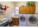 Functional laundry room featuring washer, dryer, sink, and ample storage at 12835 W Black Hill Rd, Peoria, AZ 85383