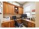 Home office space with built-in wooden cabinets, a large desk, and a window at 12835 W Black Hill Rd, Peoria, AZ 85383