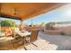 Covered patio with dining table, seating area, and a scenic backyard view at 12835 W Black Hill Rd, Peoria, AZ 85383