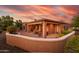 Home's rear exterior showcases a private patio and lush desert landscaping under a colorful sunset at 12835 W Black Hill Rd, Peoria, AZ 85383