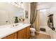 Classic bathroom with a neutral shower curtain and wooden vanity at 12936 W Sola Dr, Sun City West, AZ 85375