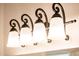 Elegant bathroom light fixture with four lights and decorative wrought iron hardware at 12936 W Sola Dr, Sun City West, AZ 85375