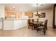 Charming dining area with views to the kitchen, elegant chandelier, and four-seat wooden table at 12936 W Sola Dr, Sun City West, AZ 85375