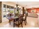 Charming dining area with views to the patio, elegant chandelier, and four-seat wooden table at 12936 W Sola Dr, Sun City West, AZ 85375