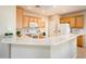 Bright kitchen featuring a breakfast bar, white appliances, and plenty of counter space at 12936 W Sola Dr, Sun City West, AZ 85375