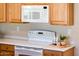 Bright kitchen featuring white countertops, an oven, a microwave, and light oak cabinets at 12936 W Sola Dr, Sun City West, AZ 85375