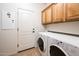 Convenient laundry room equipped with a washer, dryer, and built-in cabinets at 12936 W Sola Dr, Sun City West, AZ 85375